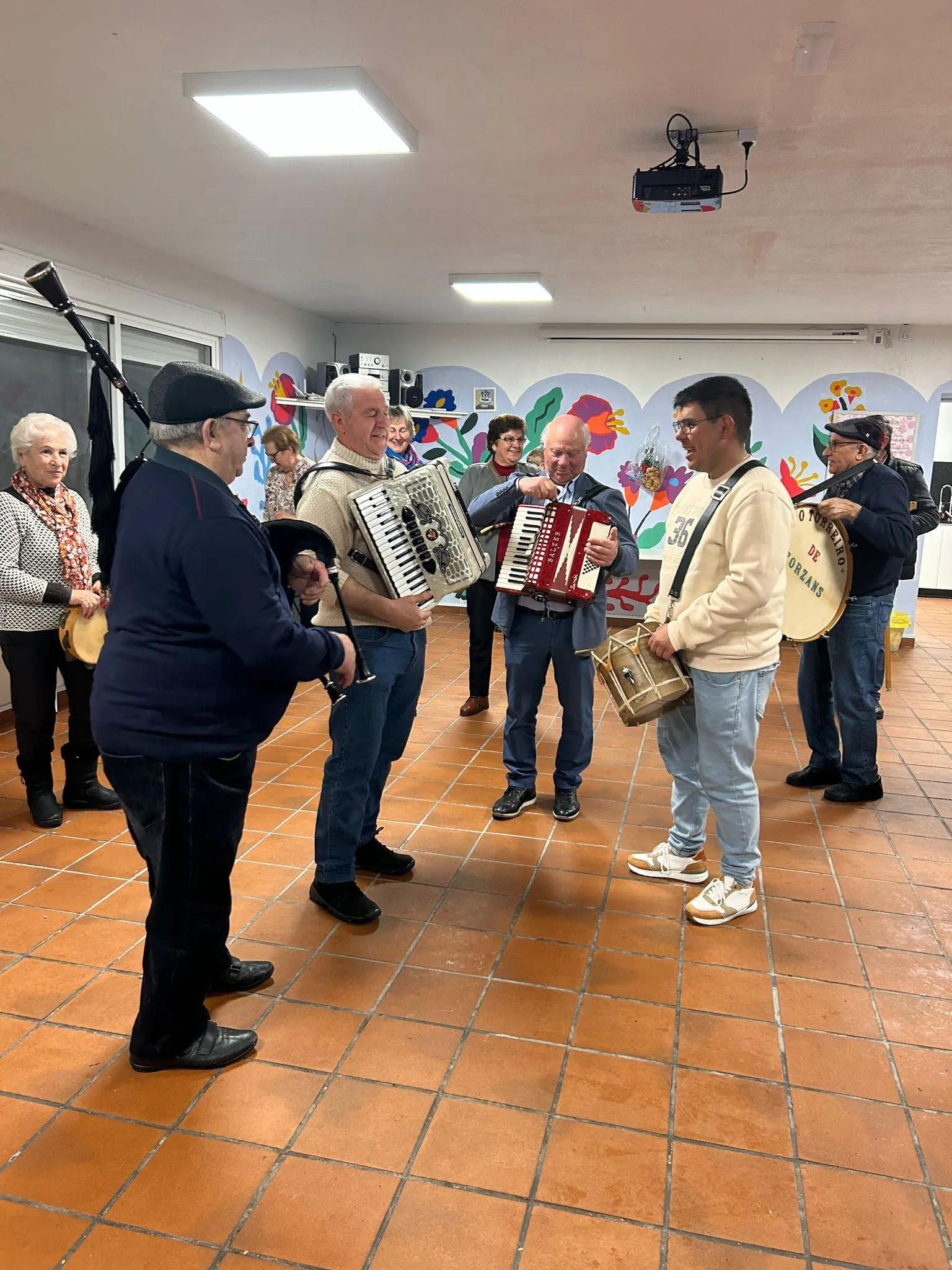 Músicos de la aldea con gaita, dos acordeones, tamboril y bombo tocando dentro de la Casa do Pobo