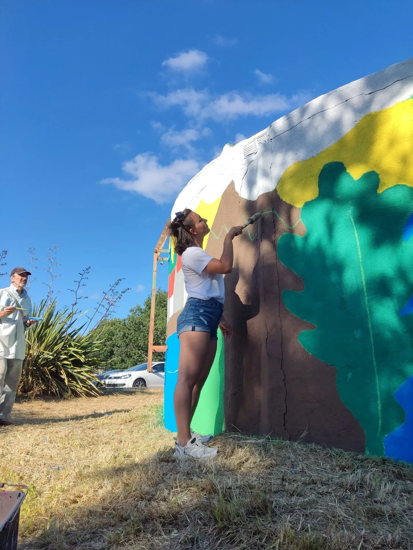 Andreea pintando o mural do depósito