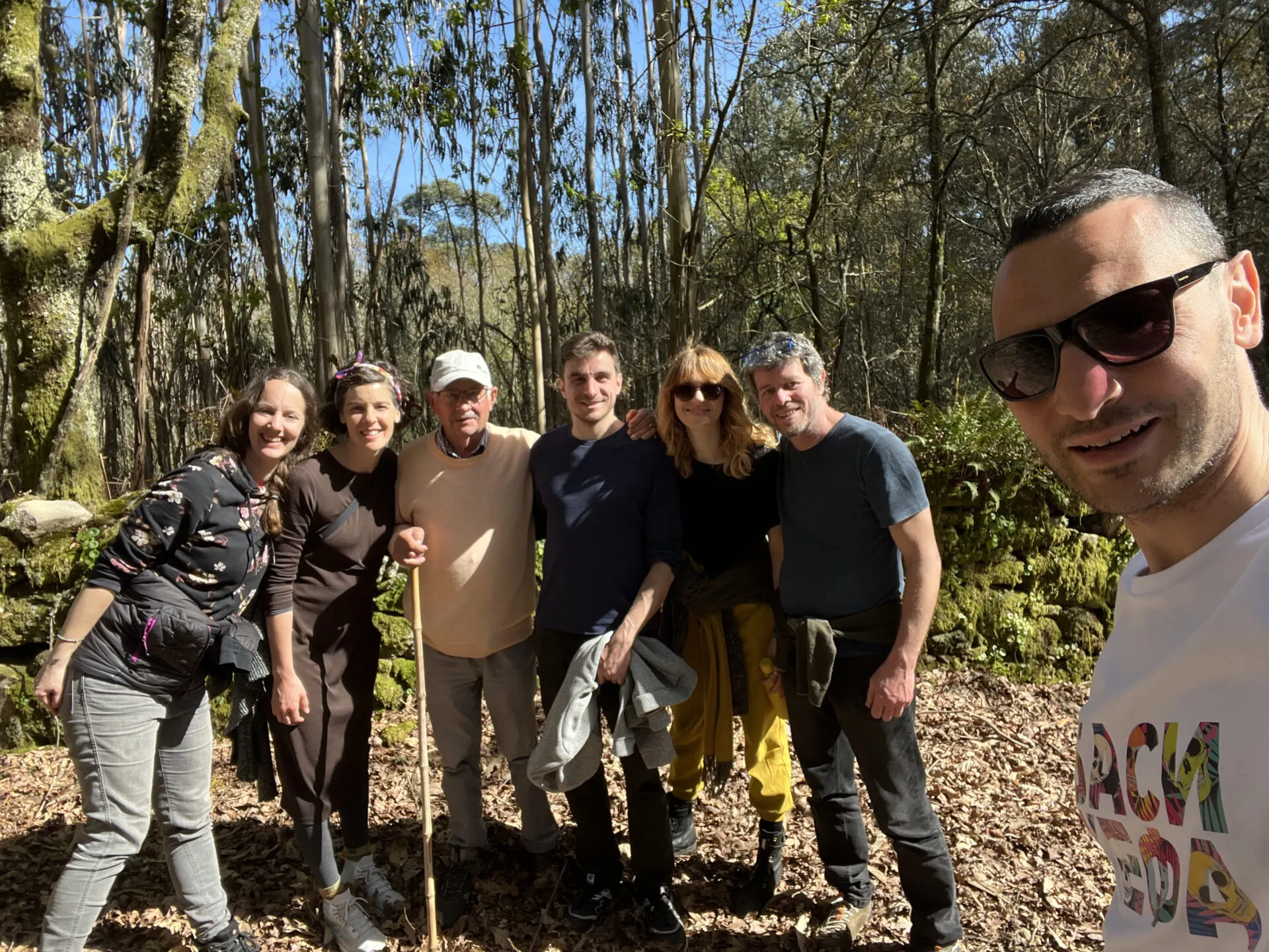 Rogelio, apoyado en un bastón, posando en el bosque con seis colivers; Agus hace el selfie en primer plano